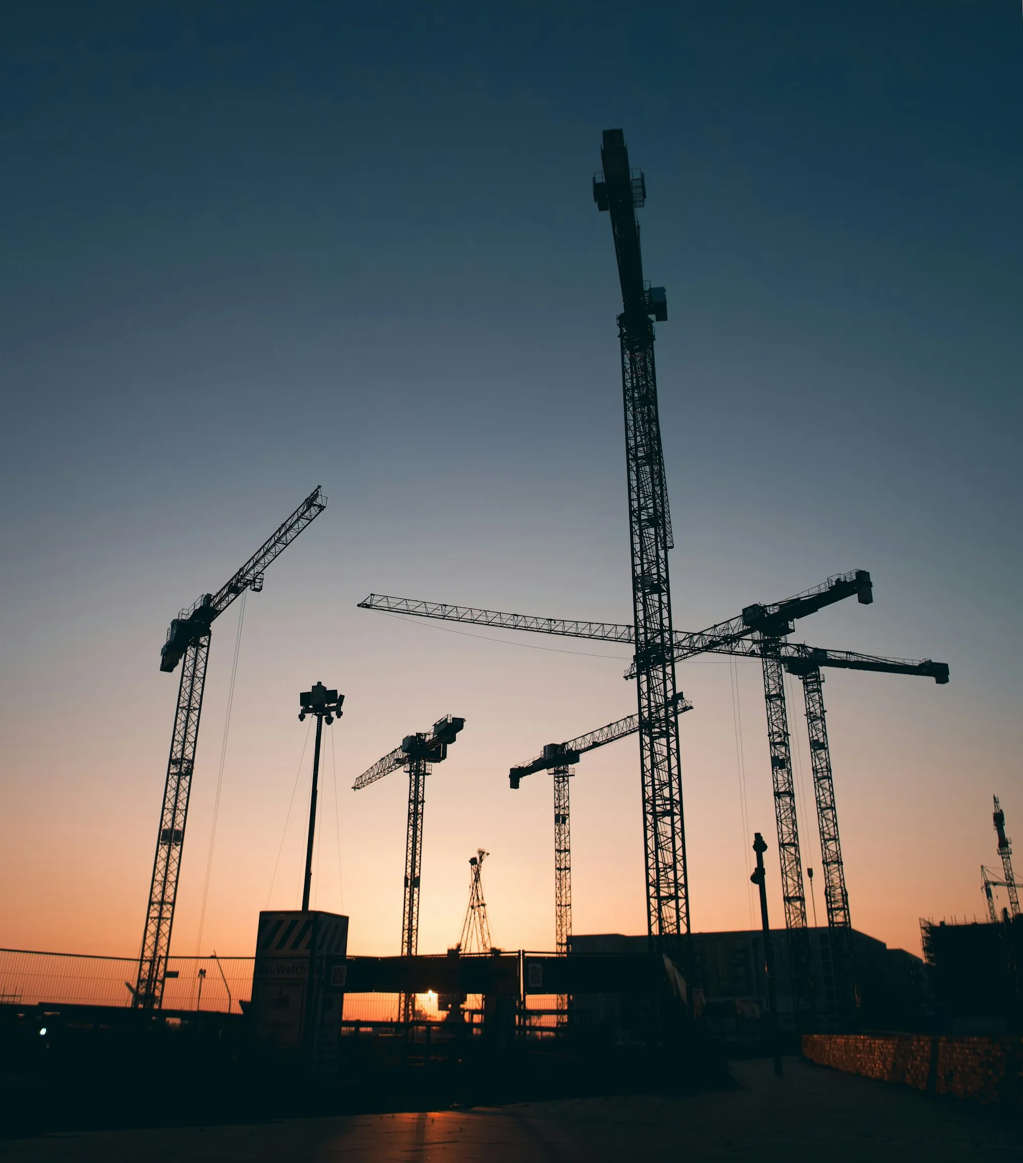 Construction cranes at dusk